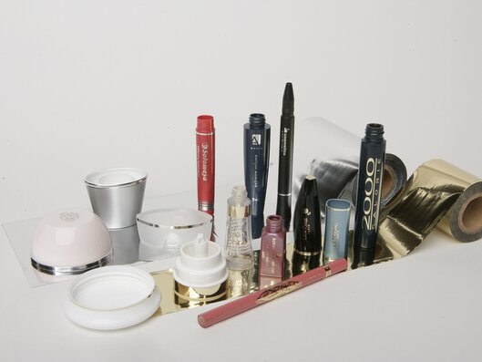 mascara, lipsticks and plastic jars on hot foil