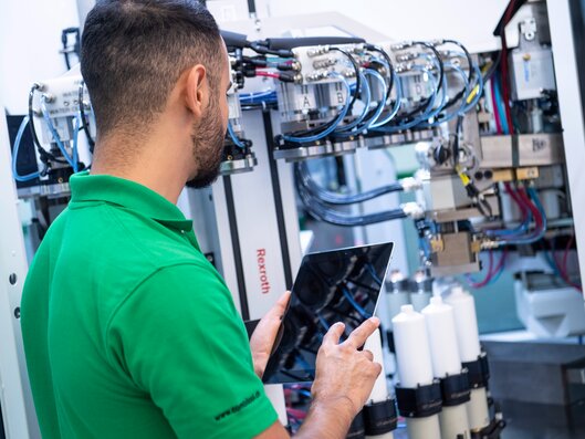man with tablet in front of machine