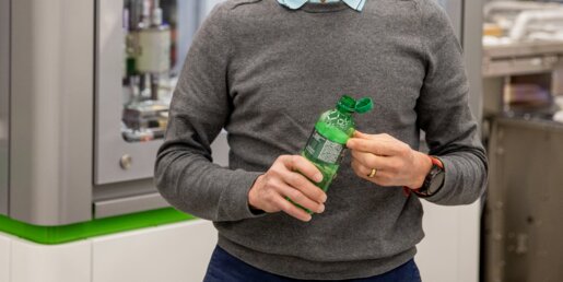 PackSys Global employee and beverage bottle with tethered closure in assembly hall