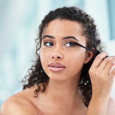 Woman putting on mascara