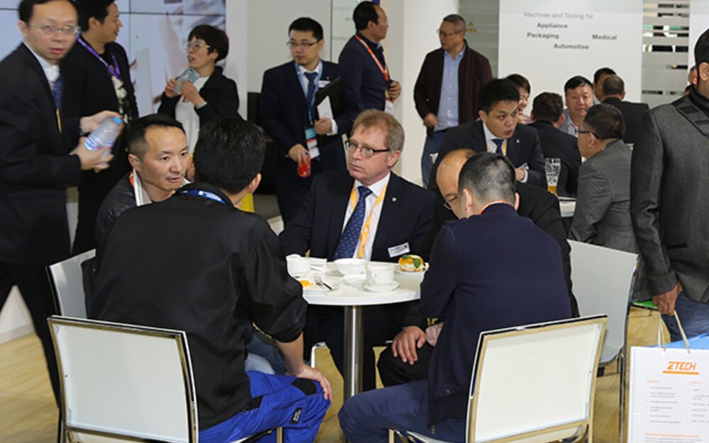 Crowded booth, lively discussions
