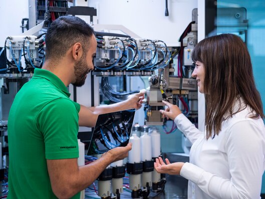 Two people discussing machine with tablet