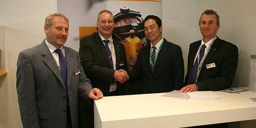 Kyung Woong Min, Vice President JK Materials Co., Ltd. (middle right) and Uwe Thönniss, Managing Director Brückner Servtec (middle left) shaking hands on the next joint upgrade project
