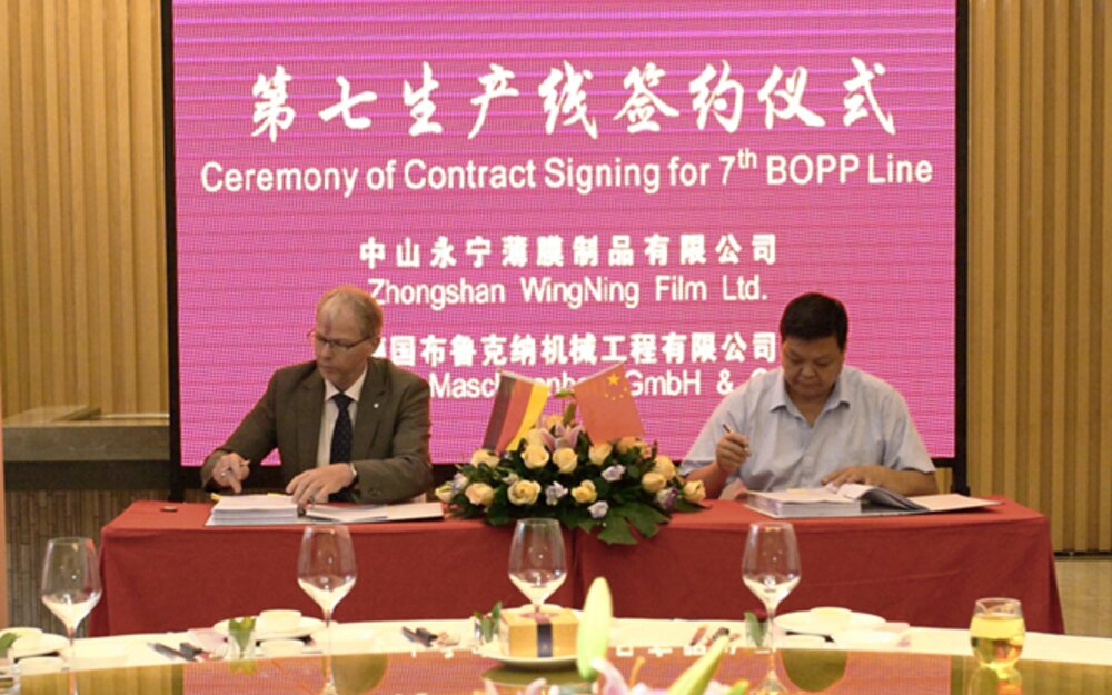 Signing of the new line: Mr. Xie, Head of WingNing and Helmut Huber, CEO Brückner Maschinenbau.
